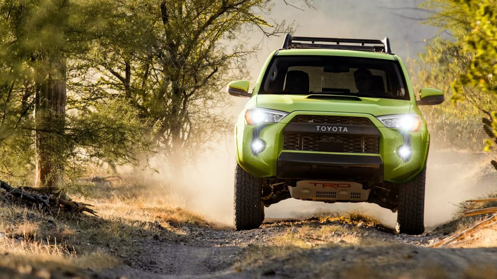Green 2022 Toyota 4Runner driving on a dirt road.