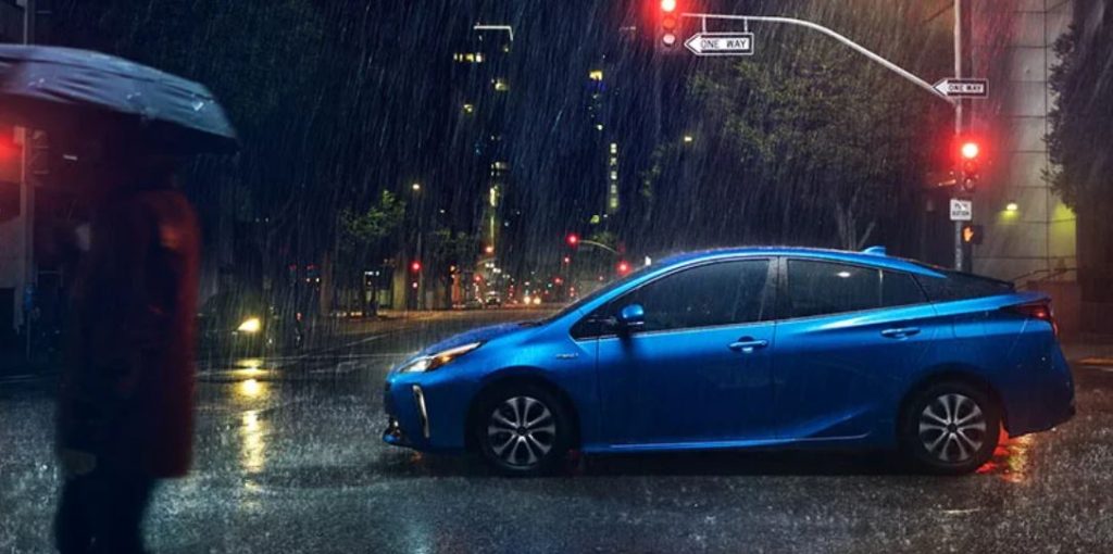A blue 2022 Prius driving in the rain.