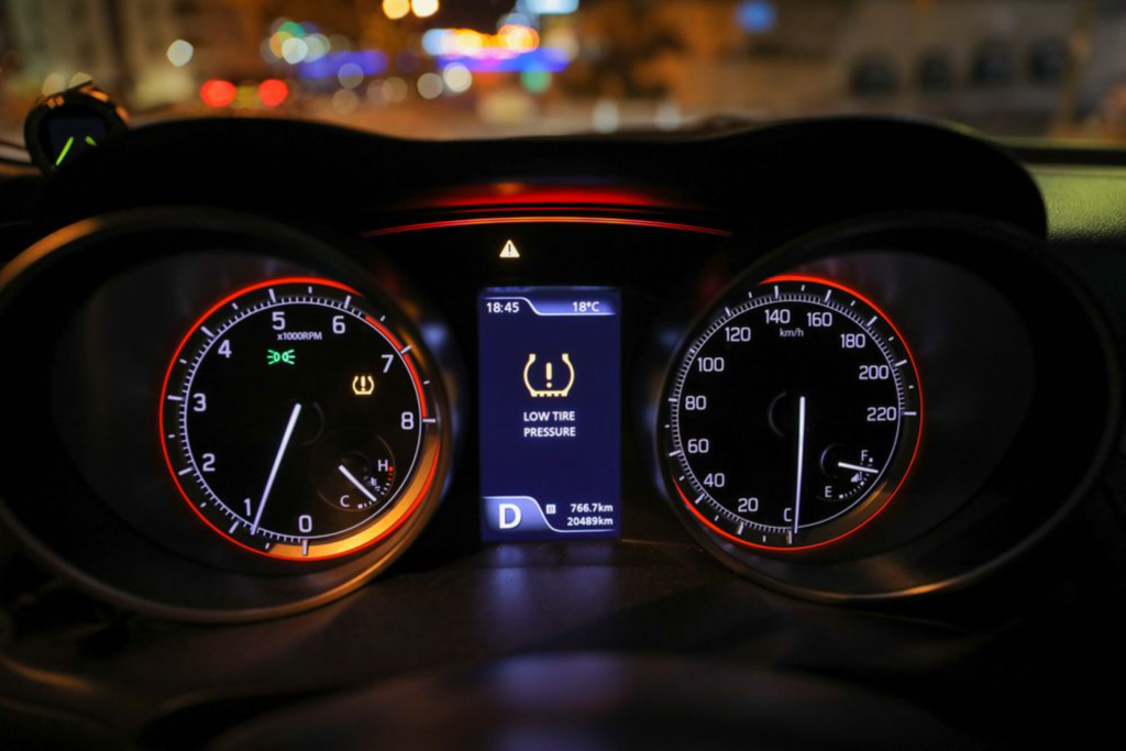 The dashboard display showing a "Low Tire Pressure" warning in a vehicle at night.