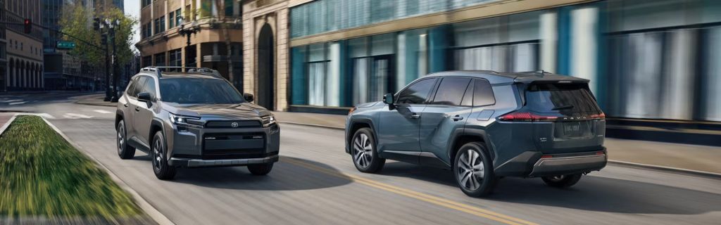Toyota RAV4 SUVs driving through an urban city street.